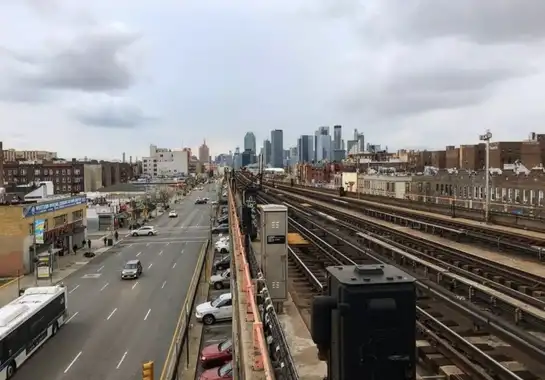 Queens New York elevated subway platform looking toward Manhattan skyline